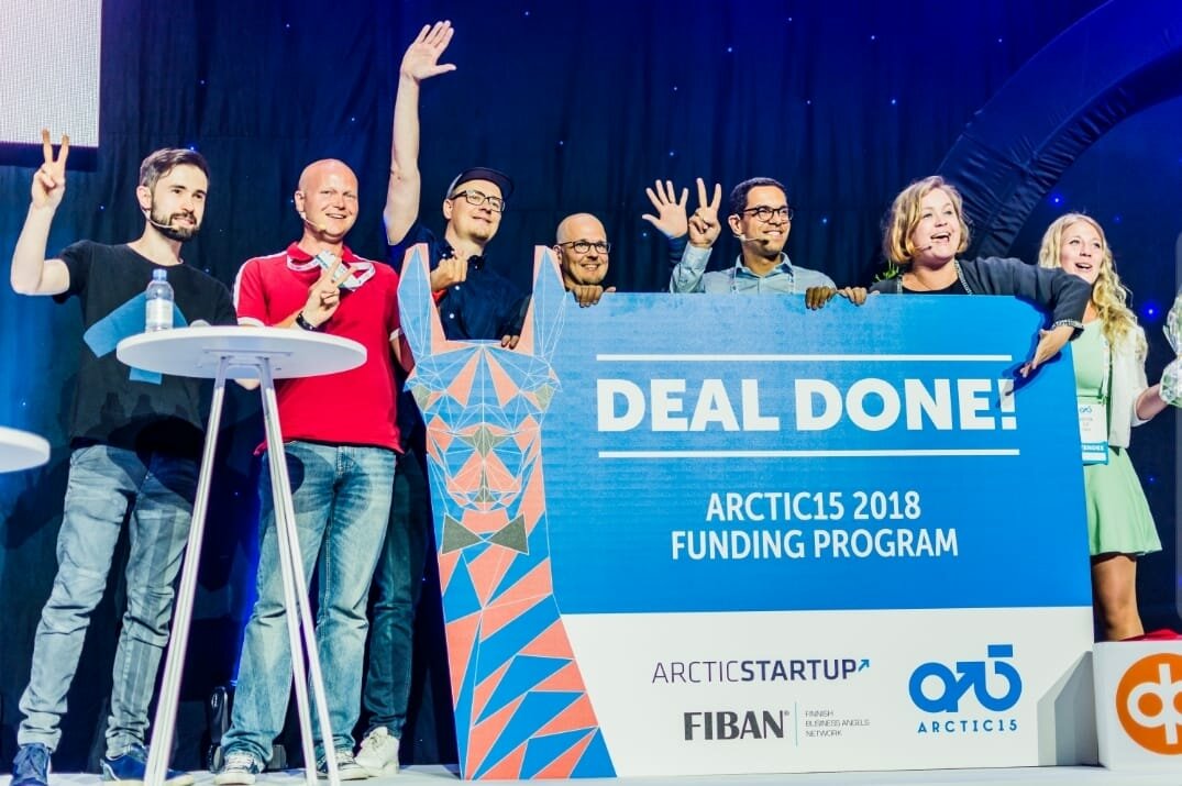 Nordic Angel Program and FiBAN team on stage holding a Deal Done! sign for the Arctic15 2018 funding programme